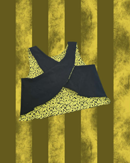 A sleeveless A Day to Remember top with a black overlay and a yellow leopard-print lining