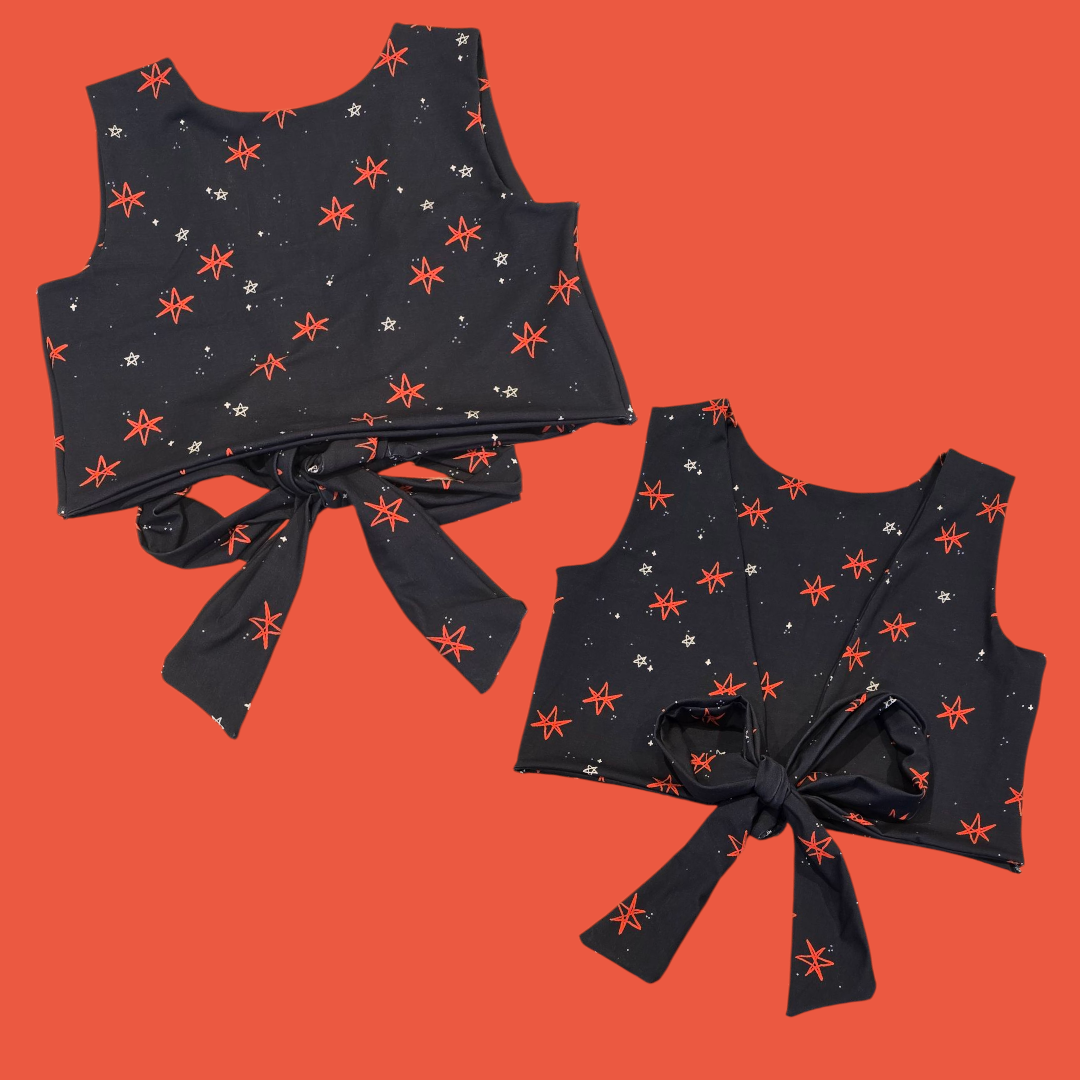 Black crop top with red star pattern on an orange background