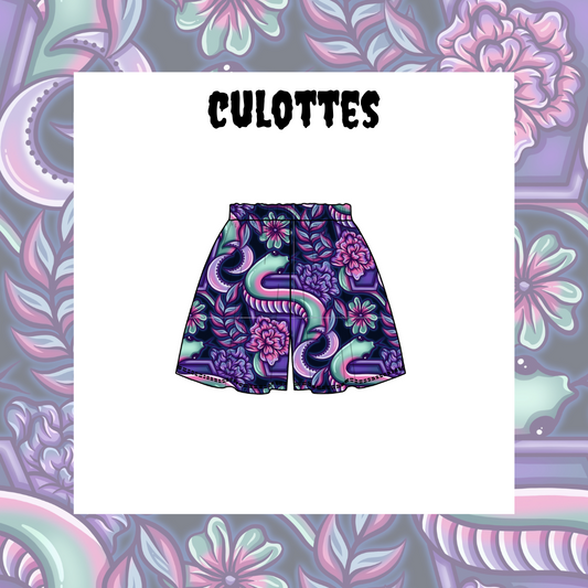 Kid's culotte shorts with a multicolored floral pattern on a purple background, displayed against a patterned background with the word 'CULOTTES' above.