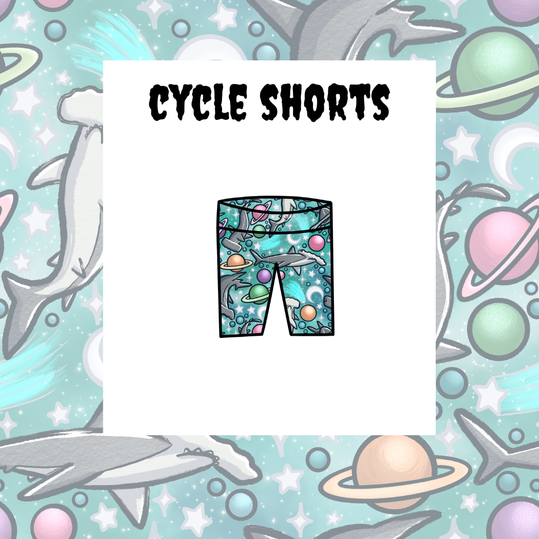 A graphic representation of kids' cycle shorts with a space and sea life theme, including planets, stars, and a shark.