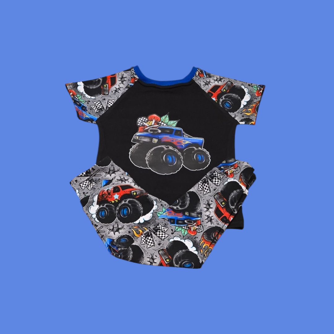 A Tshirt and leggings with a design of colorful cartoon monster trucks on a black background.