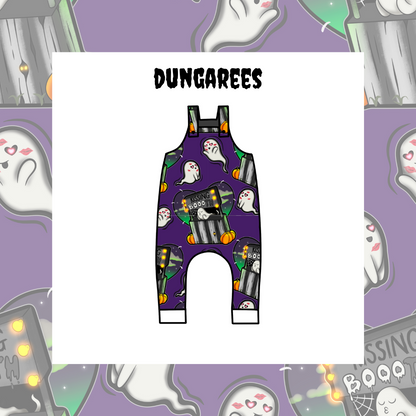 Kids' dungarees with a Halloween theme, featuring a purple background and decorated with ghosts, pumpkins, and the word 'BOO!'.