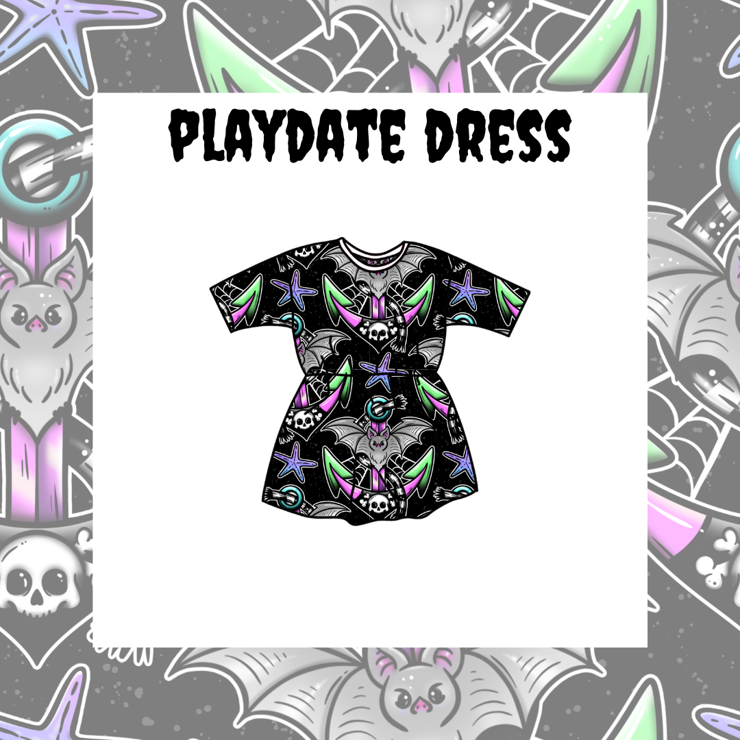 A kids' playdate dress with a black base pattern featuring purple bats, skulls, and green stars, and a floral design in purple and green colors.