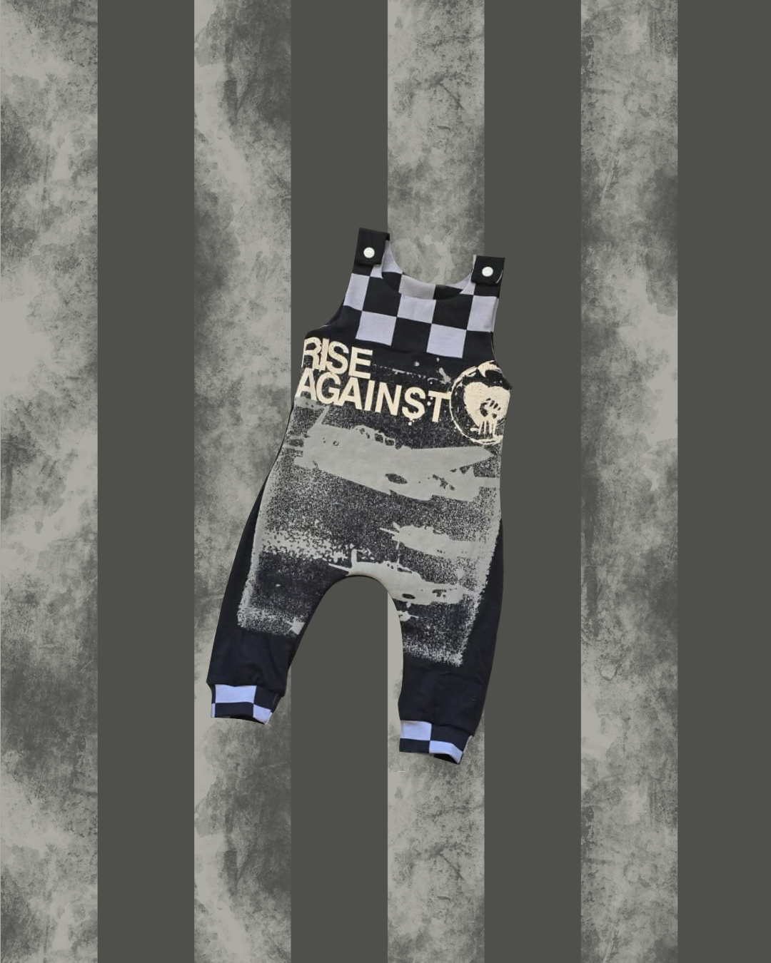 Dungarees with 'RISE AGAINST' text on a textured gray background