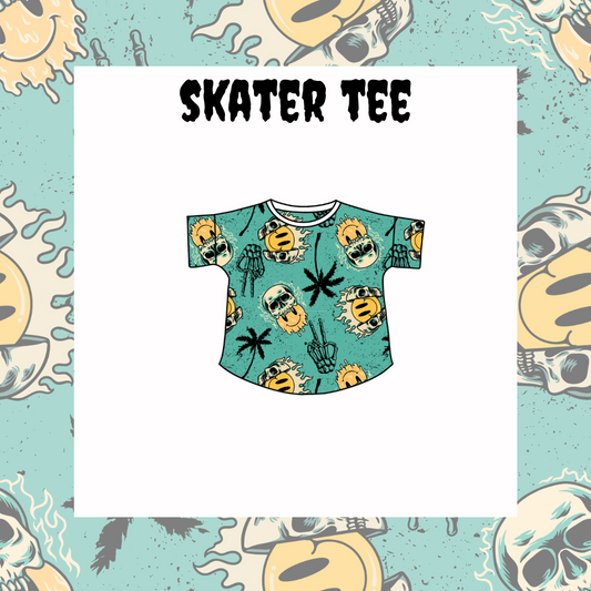 A graphic tee with a multicolored skull, pineapple, and cactus pattern on a light blue background, labeled 'SKATER TEE'.
