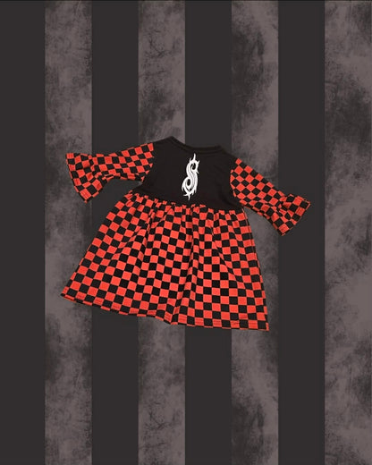 A toddler SLIPKNOT girl's dress featuring a black and red checkerboard pattern, with a solid black yoke and a white gothic dollar-sign graphic on the chest. The dress has three-quarter length flared bell sleeves.