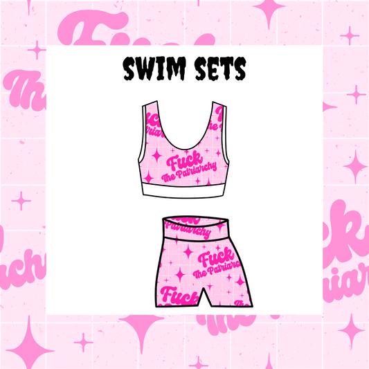 A swim set with a tankini top and shorts, both in pink with a text pattern, displayed on a background with pink confetti and stars.